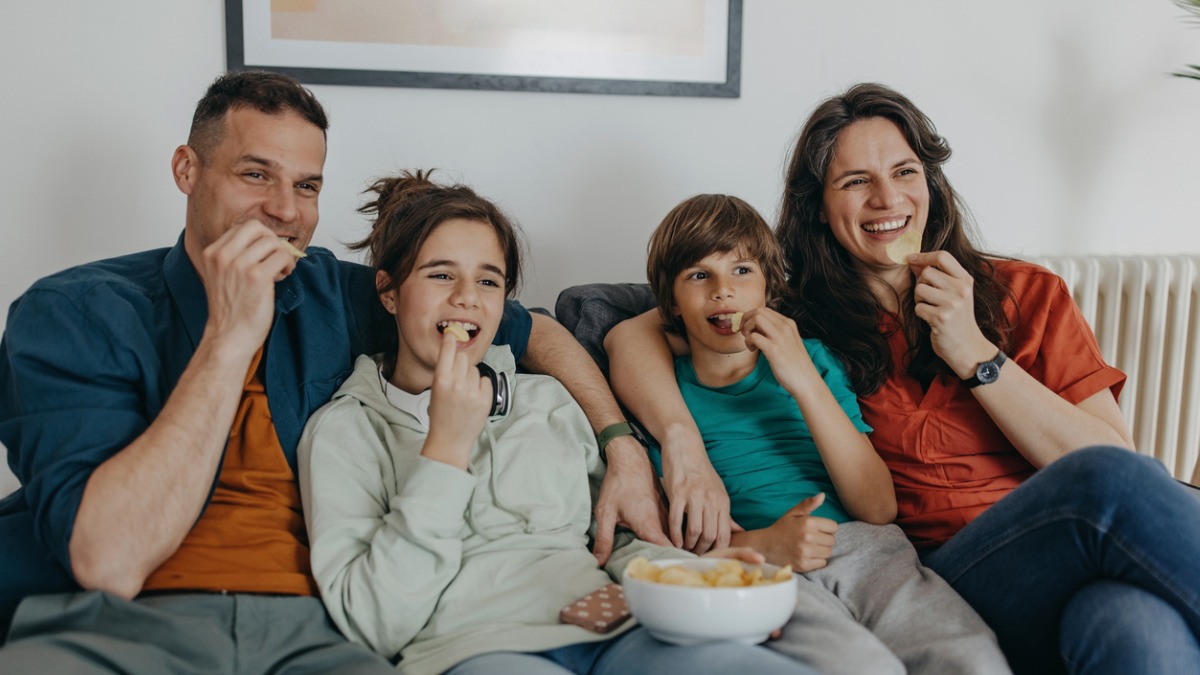 famille mange des chips devant la télévision